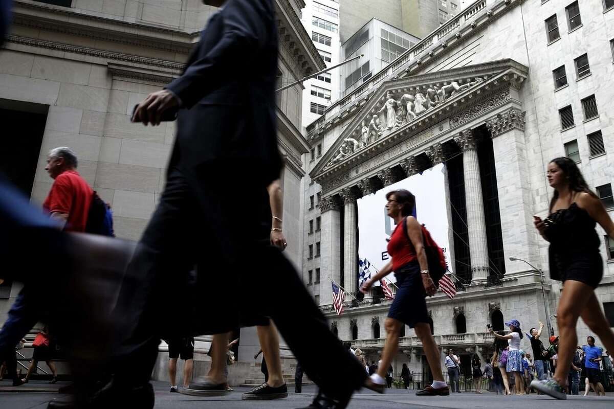 In this Monday, Aug. 24, 2015, photo, pedestrians walk past the New York Stock Exchange. Global stocks mostly fell on Monday, Aug. 31, 2015, after a U.S. Federal Reserve official suggested a September interest rate hike still was possible and weak Japanese factory activity provided more evidence of a sluggish global economy. (AP Photo/Seth Wenig)