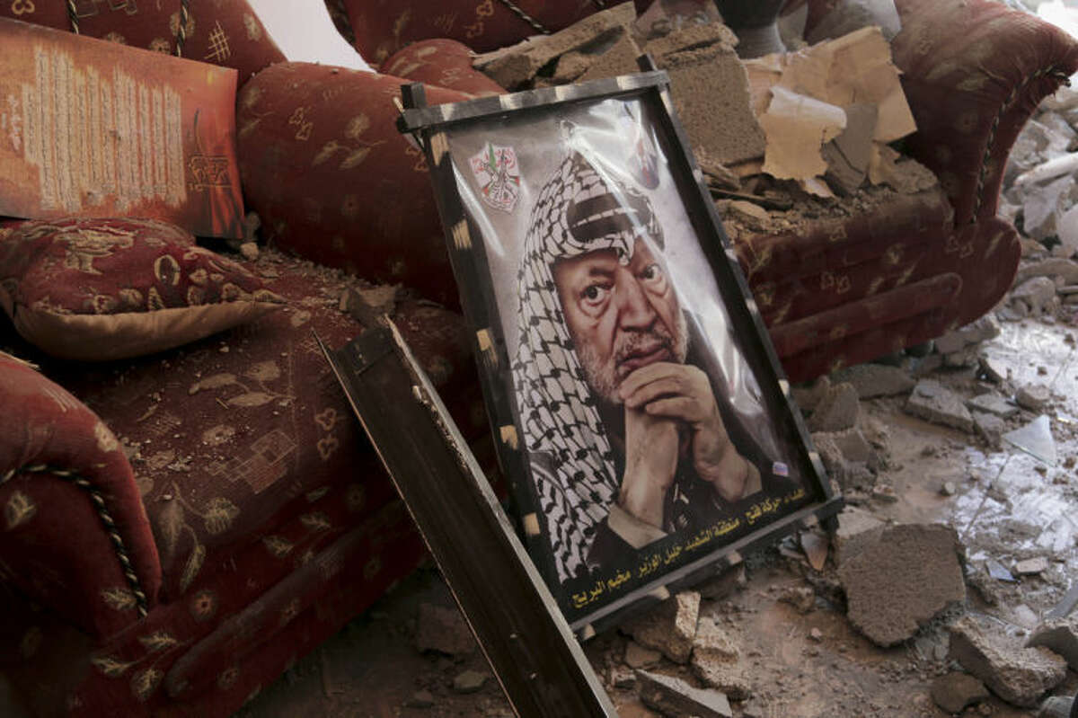 A poster of later Palestinian leader Yasser Arafat is seen on the rubble of a destroyed house in the Bureij refugee camp in the central Gaza Strip, Friday, Aug. 1, 2014. (AP Photo/Adel Hana)