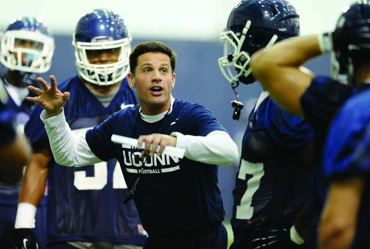 Connecticut head coach Bob Diaco, center talks to his team during the first NCAA college football practice, Saturday, Aug. 2, 2014, in Storrs, Conn. (AP Photo/Jessica Hill)