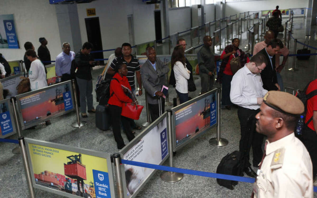 Passengers queue for their passport document check by immigration officers at the arrivals hall of Murtala Muhammed International Airport in Lagos, Nigeria, Monday, Aug. 4, 2014. Nigerian authorities on Monday confirmed a second case of Ebola in Africa's most populous country, an alarming setback as officials across the African region battle to stop the spread of the disease that has killed more than 700 people. (AP Photo/Sunday Alamba)