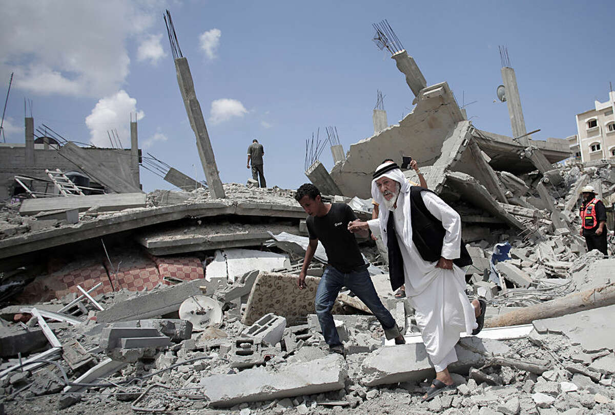 An elderly Palestinian man makes his way on the rubble of a destroyed house following Israeli strikes in Rafah refugee camp, southern Gaza Strip, Monday, Aug. 4, 2014. (AP Photo/Khalil Hamra)