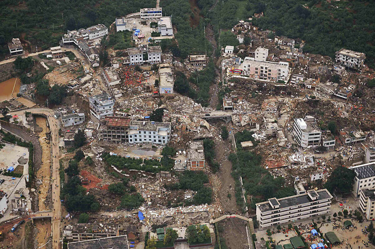 This aerial photo shows buildings toppled down by a 6.5-magnitude earthquake at the quake's epicenter in the town of Longtoushan in Ludian County of Zhaotong, southwest China's Yunnan Province, Monday, Aug. 4, 2014. Rescuers dug through shattered homes Monday looking for survivors of the strong earthquake in southern China as the death toll rose to hundreds of people, with more than 1,800 injured. (AP Photo/Xinhua, Xue Yubin) NO SALES