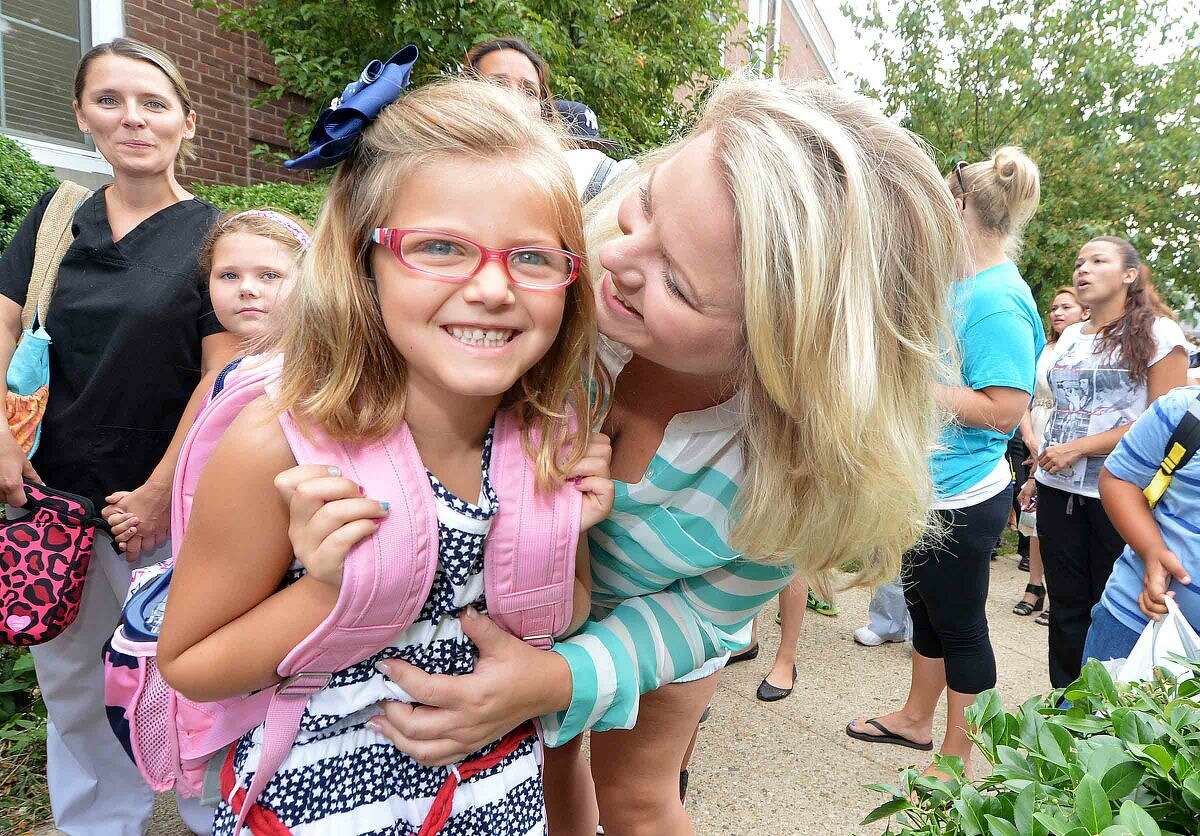 Hour Photo/Alex von Kleydorff 6yr old Allison Pennella gets a hug from mom Sara as she is off to the 1st grade at Columbus Magnet School on Monday