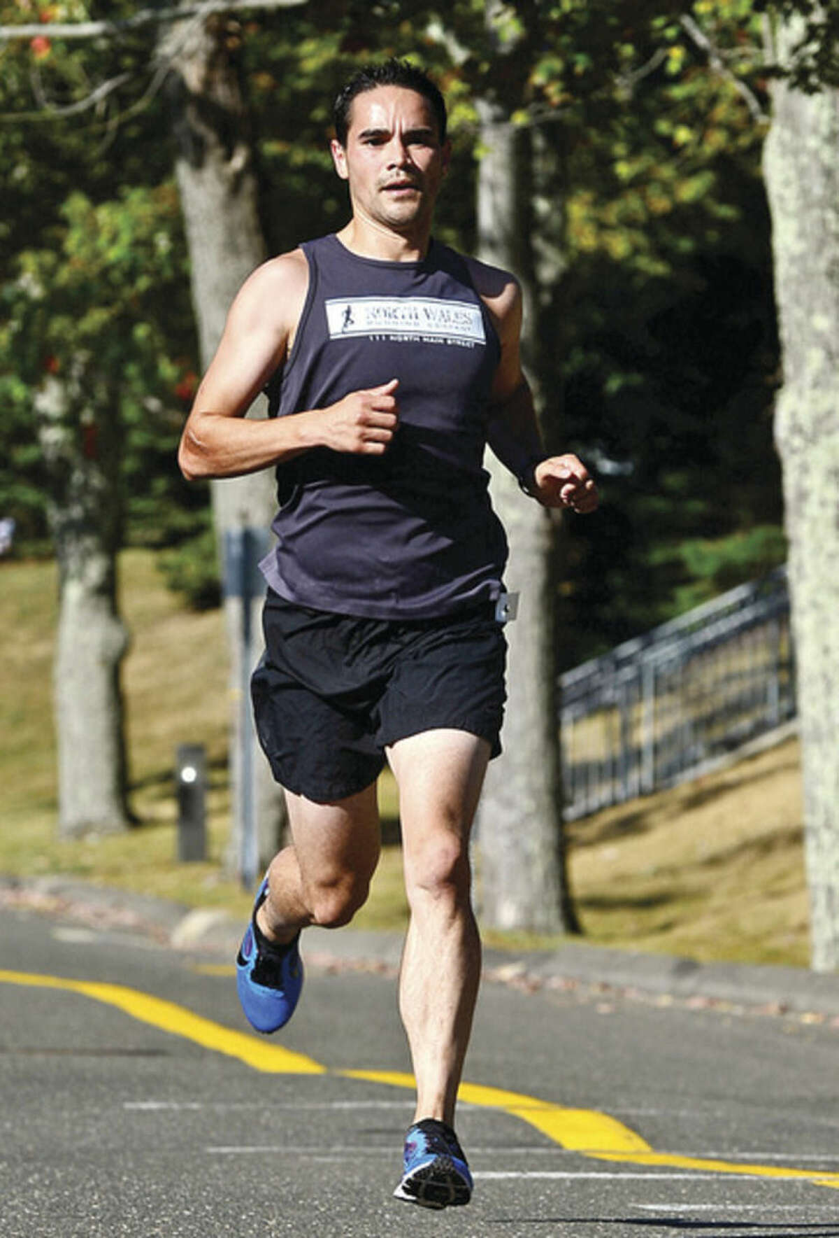 Hour photo/Erik Trautmann Ridgefield's James Osborn finishes first during the Westport Road Runners Summer Series 10-mile race on Saturday at Staples High School.