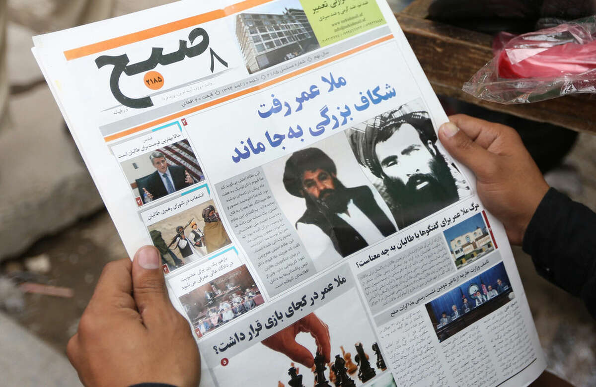 FILE - In this Saturday, Aug. 1, 2015 file photo, an Afghan man reads a local newspaper with photos of the new leader of the Afghan Taliban, Mullah Akhtar Mansoor, center, and former leader Mullah Mohammad Omar who was declared dead, in Kabul, Afghanistan. Loyalists of the Islamic State group are making inroads into Afghanistan, with homegrown militants claiming fealty to IS controlling territory in some parts of the country and ruling in the same harsh fashion witnessed in Iraq and Syria, officials, military leaders and analysts said. (AP Photo/Massoud Hossaini, File)