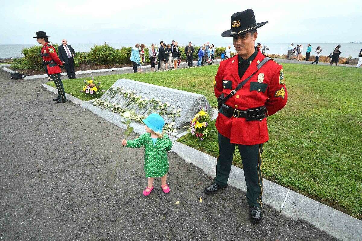 Hour Photo/Alex von Kleydorff During the Connecticut Remembers September 11th Memorial Ceremony 2 yr old Cece Butzbaugh looks for just the right spot to place the white rose she has for her uncle John Henwood