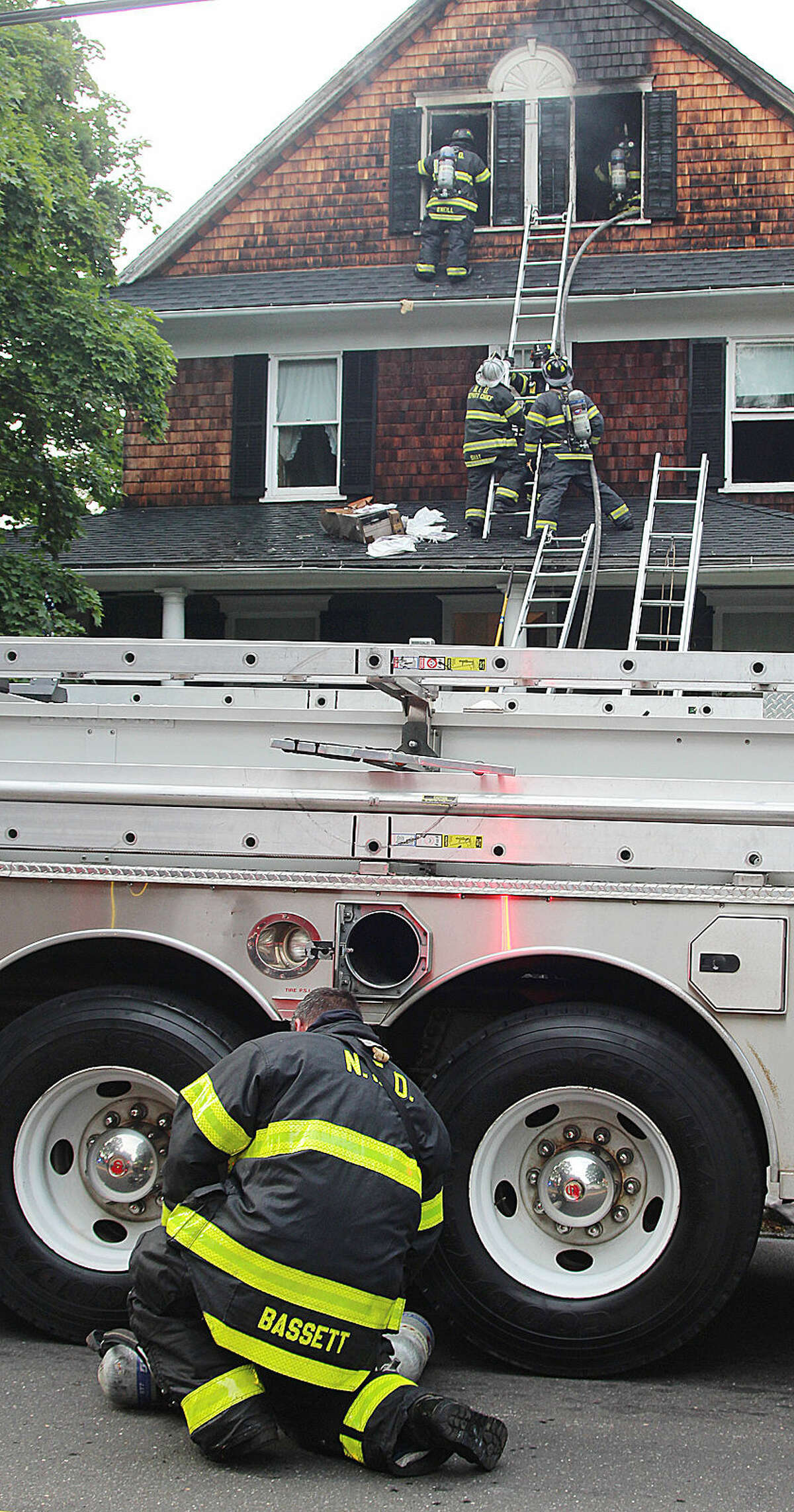 Hour photo / Chris Bosak Firefighters battle a fire at 1 Cannon St. in Norwalk on Monday evening.