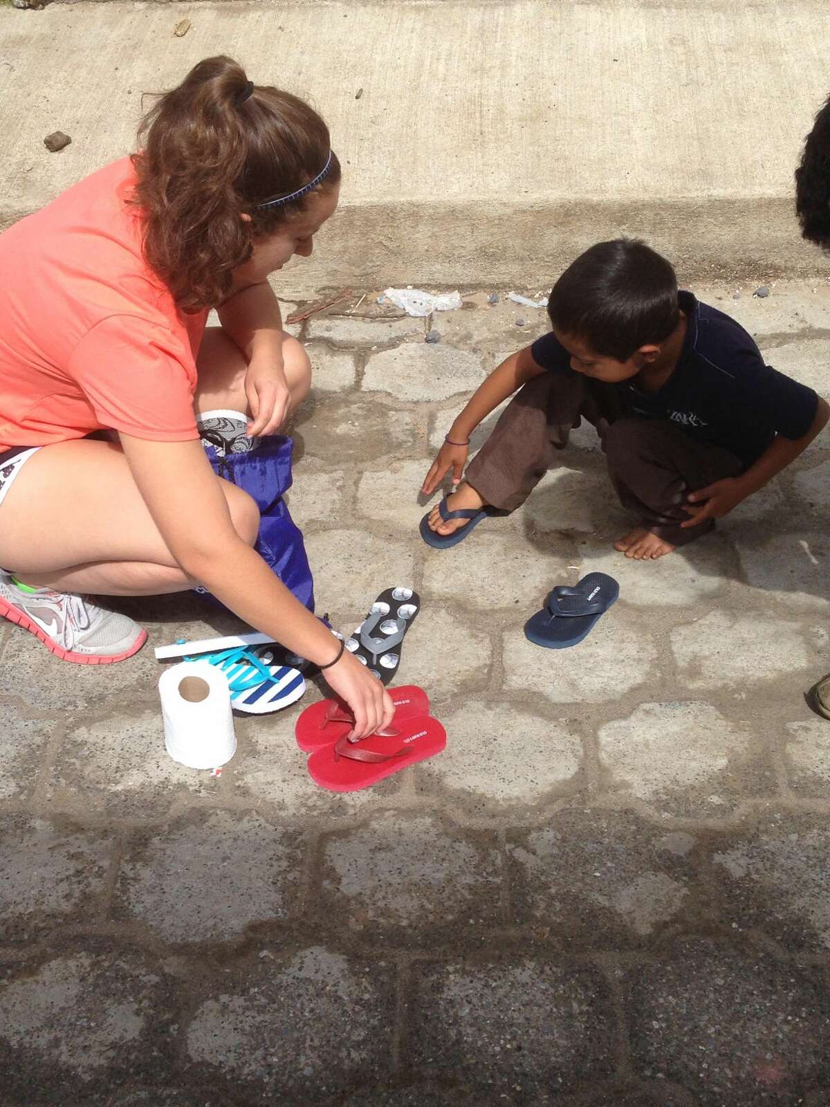 Contributed photo Rev. Artie Kassimis's Nicolette daughter gives shoes to a Guatemalan boy.