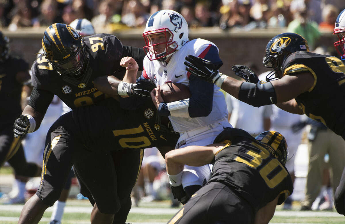 Connecticut quarterback Bryant Shirreffs, center, is gang tackled by Missouri's Rickey Hatley, right, Josh Augusta, left, Michael Scherer (30) and Kentrell Brothers (10) during the fourth quarter of an NCAA college football game Saturday, Sept. 19, 2015, in Columbia, Mo. Missouri won the game 9-6. (AP Photo/L.G. Patterson)