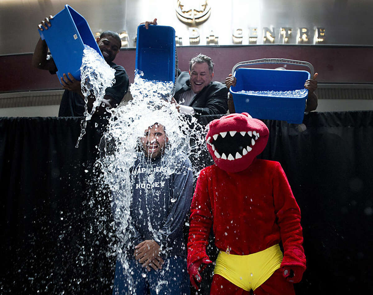 Nazem Kadri, bottom left, of the Maple Leafs and the Raptor, bottom right, participate in the ALS Ice Bucket Challenge as Jermain Defoe, top right, of Toronto FC, Amir Johnson, left, of the Toronto Raptors and Tim Leiweke, center, President and CEO of Maple Leaf Sports Entertainment dump water on them in Toronto on Wednesday, Aug. 20, 2014. (AP Photo/The Canadian Press, Nathan Denette)