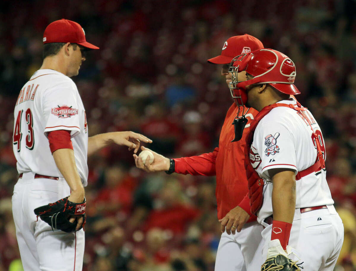 Cincinnati Reds Manny Parra get taken out of the game by manager Bryan Price and catcher Brayan Pena against the New York Mets in the seventh inning of a baseball game in Cincinnati, Thursday, Sept. 24, 2015. (AP Photo/Tom Uhlman)