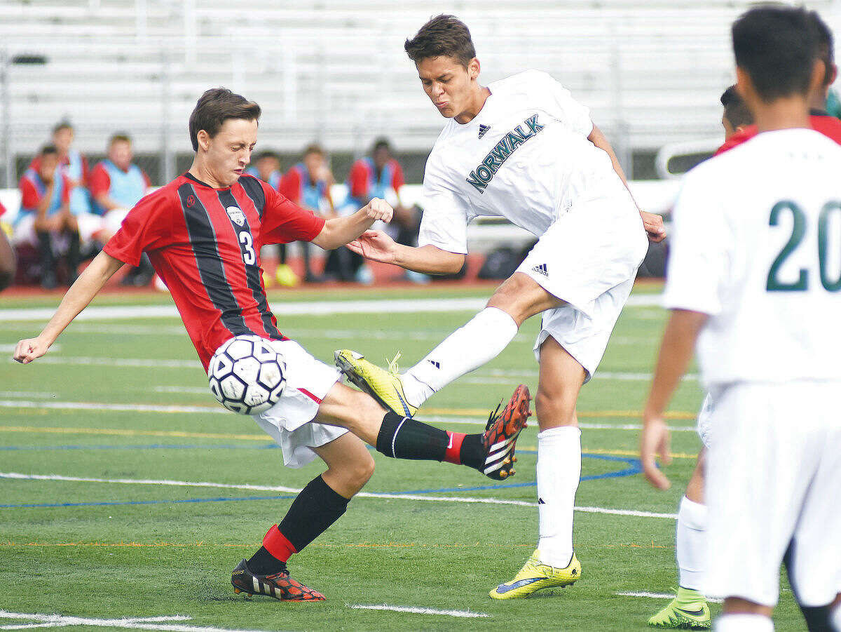 Hour photo/John Nash - Norwalk's Santiago Mesa, center, looks to get off a shot as Bridgeport Central defender Victor Pieriera interferes during the first half of Tuesday's FCIAC boys soccer game at Testa Field in Norwalk.