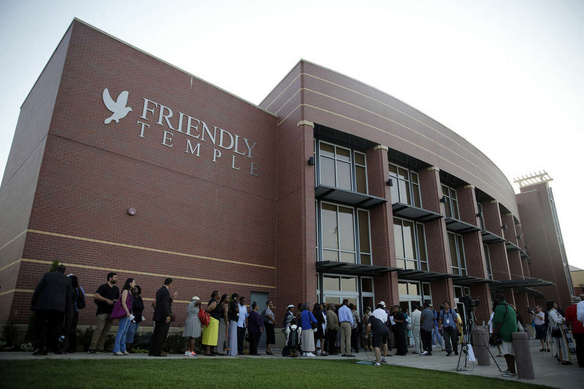People begin to line up to attend the funeral for Michael Brown, Monday, Aug. 25, 2014, in St. Louis. Brown, who is black, was unarmed when he was shot Aug. 9 by Officer Darren Wilson, who is white. A grand jury is considering evidence in the case and a federal investigation is also underway. (AP Photo/Jeff Roberson)
