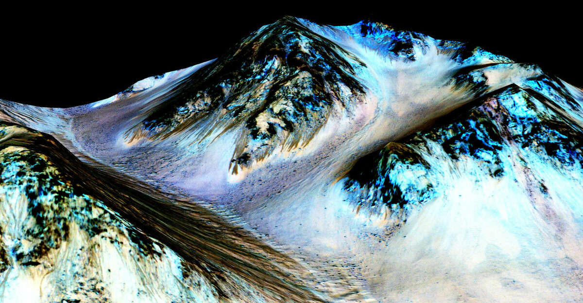 This undated photo provided by NASA and taken by an instrument aboard the agency's Mars Reconnaissance Orbiter shows dark, narrow, 100 meter-long streaks on the surface of Mars that scientists believe were caused by flowing streams of salty water. Researchers said Monday, Sept. 28, 2015, that the latest observations strongly support the longtime theory that salt water in liquid form flows down certain Martian slopes each summer. (NASA/JPL/University of Arizona via AP)