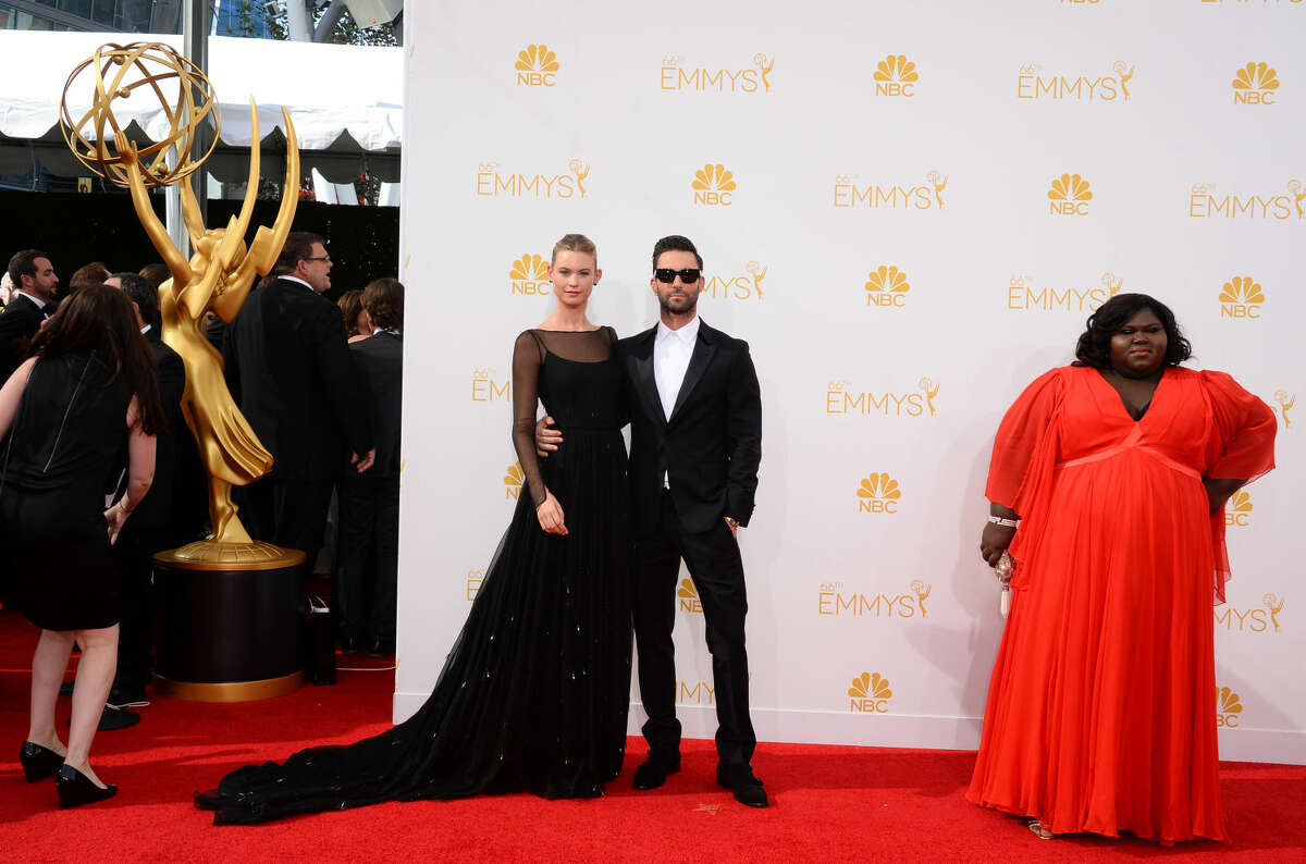 Behati Prinsloo, and from left, Adam Levine and Gabourey Sidibe arrive at the 66th Annual Primetime Emmy Awards at the Nokia Theatre L.A. Live on Monday, Aug. 25, 2014, in Los Angeles. (Photo by Jordan Strauss/Invision/AP)