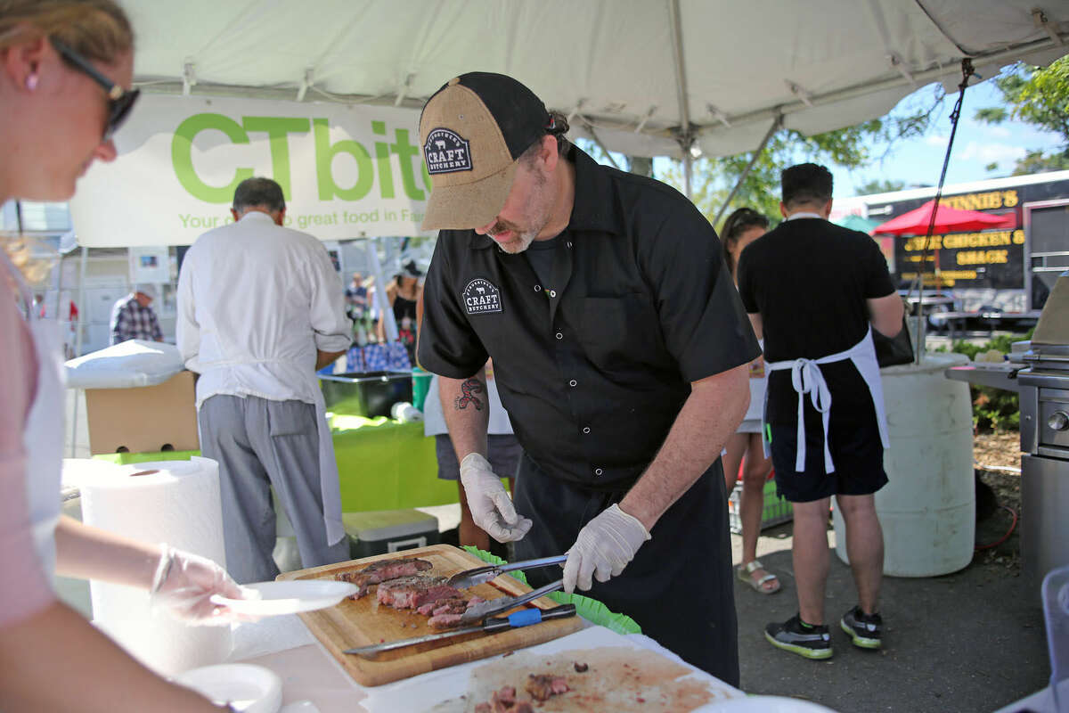 Saugatuck Craft Butchery's Mark Hepperman serves up some meat under the CT Bites tent during the 7th Annual Blues, Views & BBQ Festival Saturday at Levitt Pavilion and the Westport Library. Hour Photo / Danielle Calloway