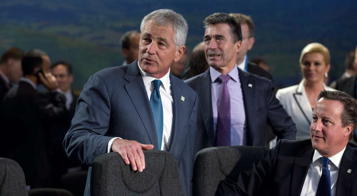 From front right, British Prime Minister David Cameron, NATO Secretary General Anders Fogh Rasmussen and U.S. Defense Minister Chuck Hagel wait for the start of a round table meeting of the North Atlantic Council during a NATO summit at the Celtic Manor Resort in Newport, Wales on Friday, Sept. 5, 2014. (AP Photo/Virginia Mayo)