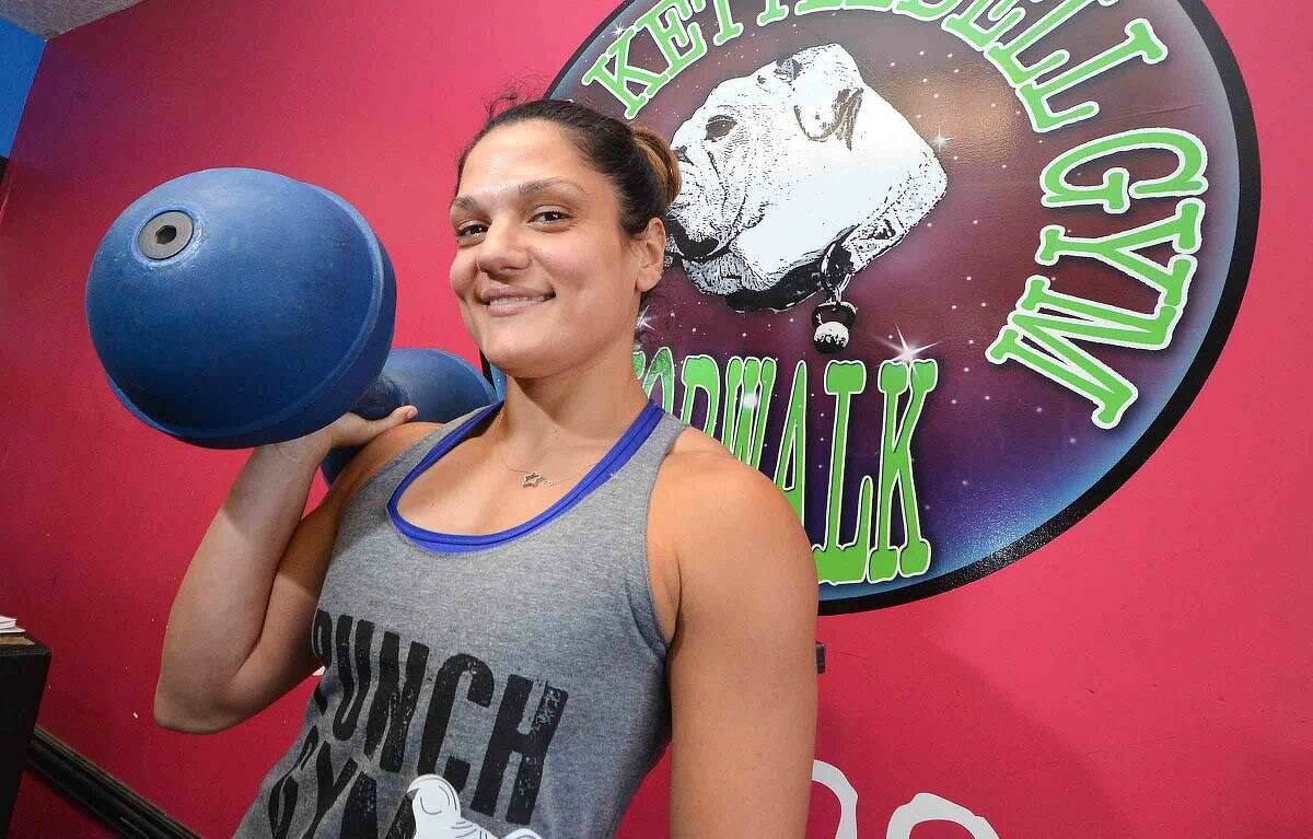 Owner Stefanie Tropea with a 50 pound circus dumbbell in her Punch Gym on Main Avenue in Norwalk.