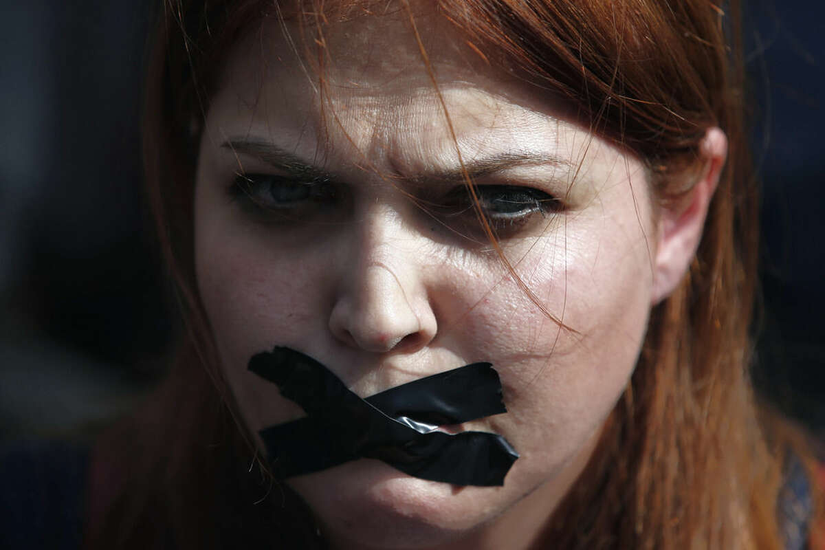 A woman places a bandage other mouth as she protests Saturday's explosions in Ankara, Turkey, Tuesday, Oct. 13, 2015. Authorities in Istanbul banned a protest rally and march by the same trade union and civic society groups who lost friends and colleagues in Turkey's bloodiest terror attack. Dogan news agency video footage on Tuesday showed police pushing back dozens of demonstrators trying to reach the rally to commemorate the 97 victims of the twin suicide bombings. Some demonstrators were detained.(AP Photo/Emrah Gurel)