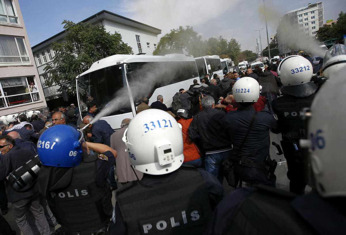 Police use teargas to disperse people who were protesting Saturday's explosions in Ankara, Turkey, Tuesday, Oct. 13, 2015. Authorities in Istanbul banned a protest rally and march by the same trade union and civic society groups who lost friends and colleagues in Turkey's bloodiest terror attack. Dogan news agency video footage on Tuesday showed police pushing back dozens of demonstrators trying to reach the rally to commemorate the 97 victims of the twin suicide bombings. Some demonstrators were detained.(AP Photo/Emrah Gurel)
