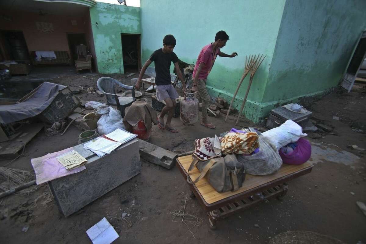 Flood affected Indian villagers salvage their belongings on the outskirts of Jammu, India, Monday, Sept. 8, 2014. Six days of rains in Indian Kashmir have left more than 120 people dead in the region's worst flooding in more than five decades, submerging hundreds of villages and triggering landslides, officials said. (AP Photo/Channi Anand)
