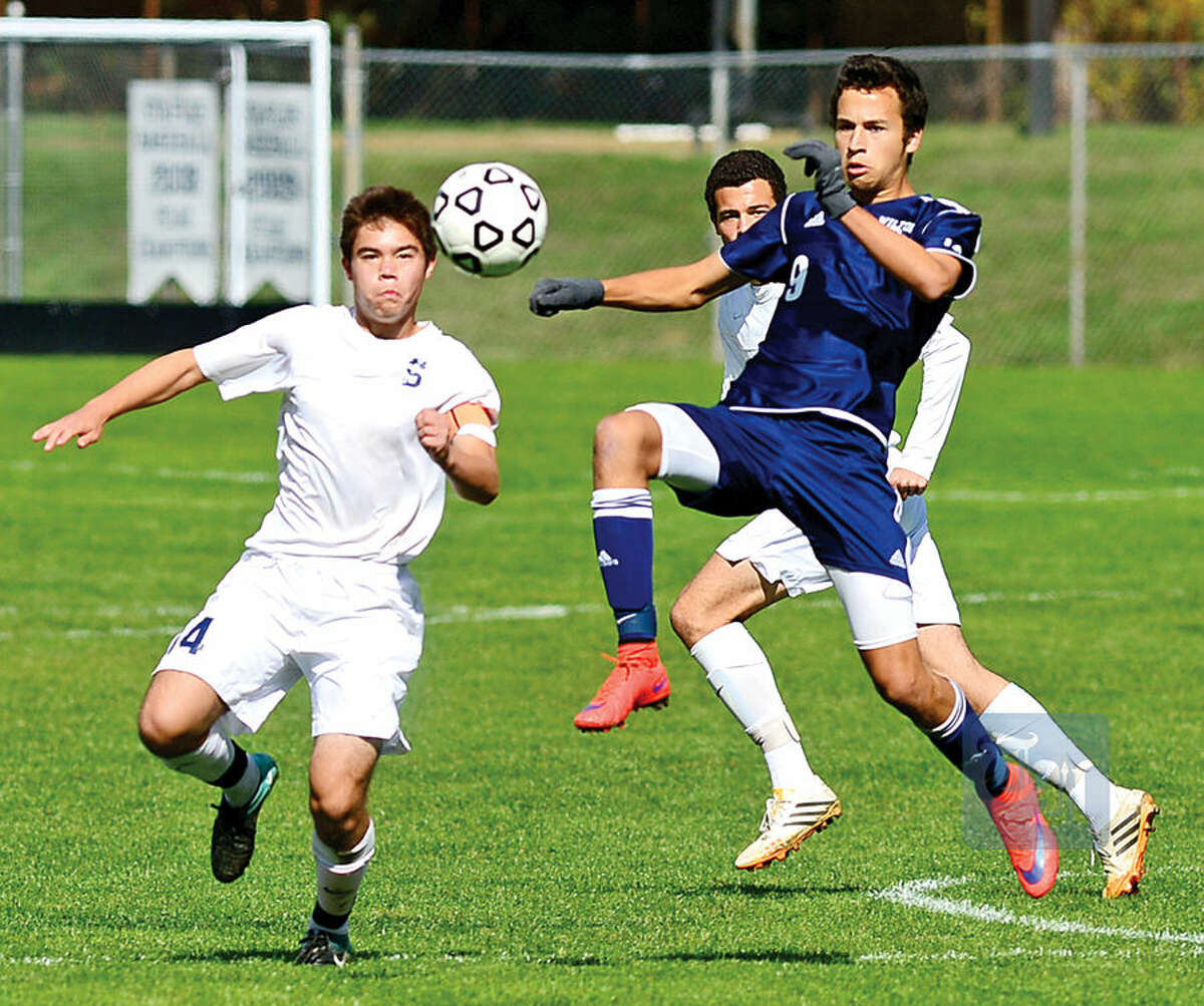 Hour photo / Erik Trautmann Wilton High School's #9 Harry Allers gets the ball away from Staples' #14 Kenji Goto in their boys soccer game Saturday in Westport.