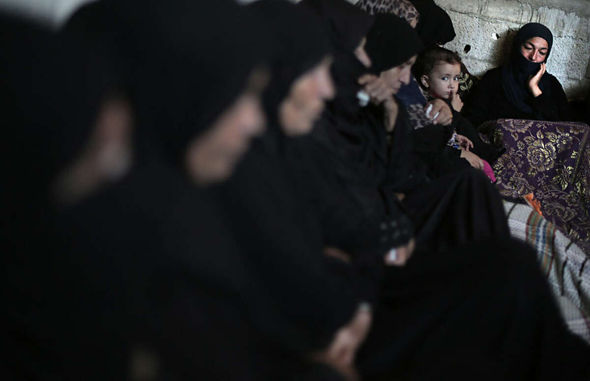 Palestinian women mourn at the family house of Ahmed Al-Serhi, 27, who was killed during clashes with Israeli troops near the Israeli border with Gaza, during his funeral in Deir el-Balah, in the central Gaza Strip, Wednesday, Oct. 21, 2015. (AP Photo/ Khalil Hamra)