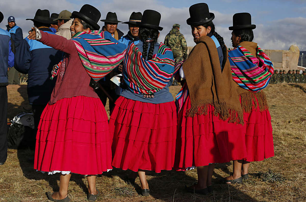 Aymara women take part in a ceremony celebrating Bolivia's President Evo Morales time in office, during a traditional Andean ritual at the archeological site Tiwanaku, Bolivia, Wednesday, Oct. 21, 2015. Morales celebrated on Wednesday as the leader who's led Bolivia for the most years continuously, almost 10 year, surpassing the mark of one of Bolivia's founders, Marshal Andres de Santa Cruz. "We're making history by setting a record, but not just in terms of time," he said, pointing out his government's achievements. (AP Photo/Juan Karita)