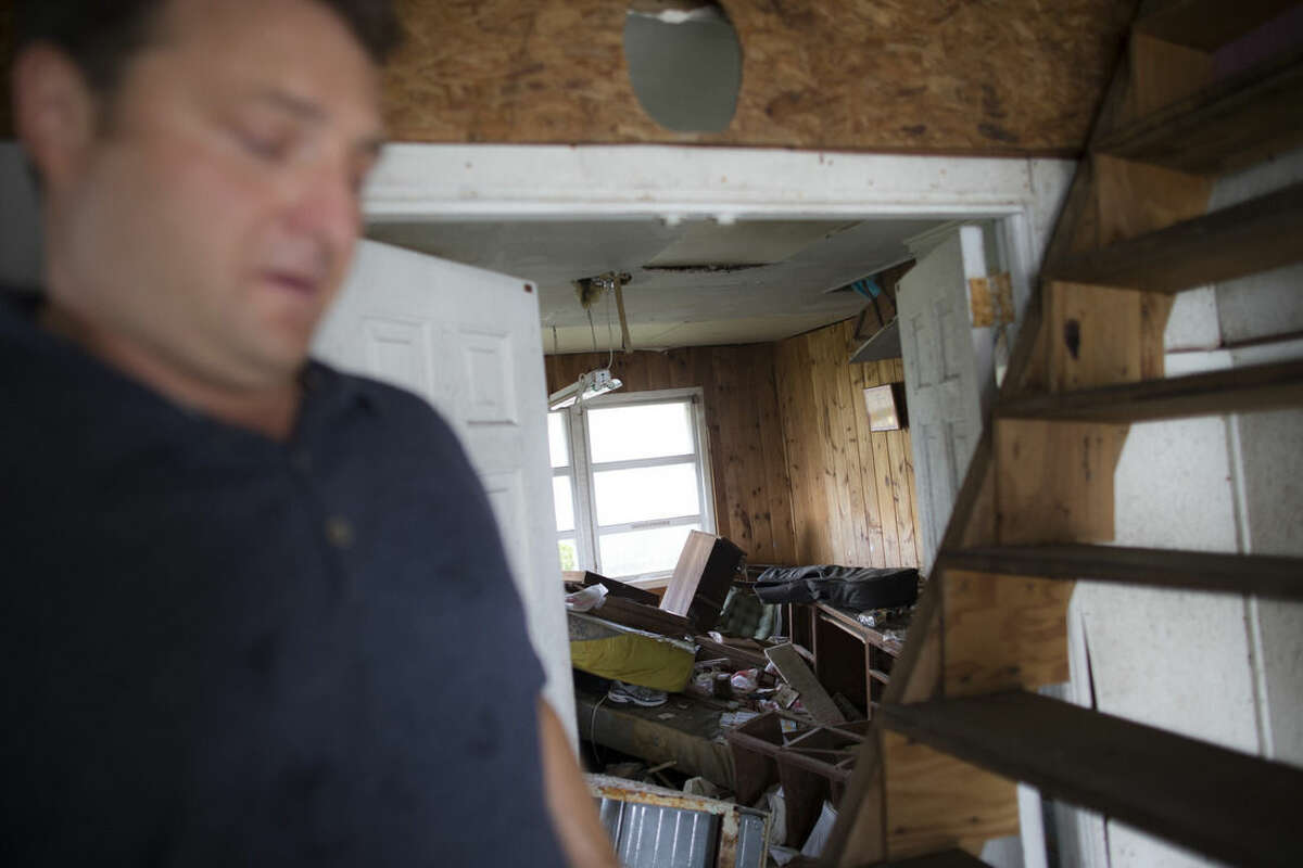 In this Sept. 5, 2014 photo, Gary Silberman guides reporters on a tour of his parent's home that was destroyed by Superstorm Sandy in Lindenhurst, N.Y. After receiving nearly $17,000 in assistance from FEMA, the agency is demanding a return on the funds. (AP Photo/John Minchillo)