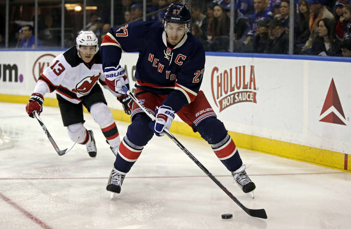 New York Rangers defenseman Ryan McDonagh (27) controls the puck in front of New Jersey Devils left wing Mike Cammalleri during the first period of an NHL hockey game at Madison Square Garden on Sunday, Oct. 18, 2015, in New York. (AP Photo/Adam Hunger)