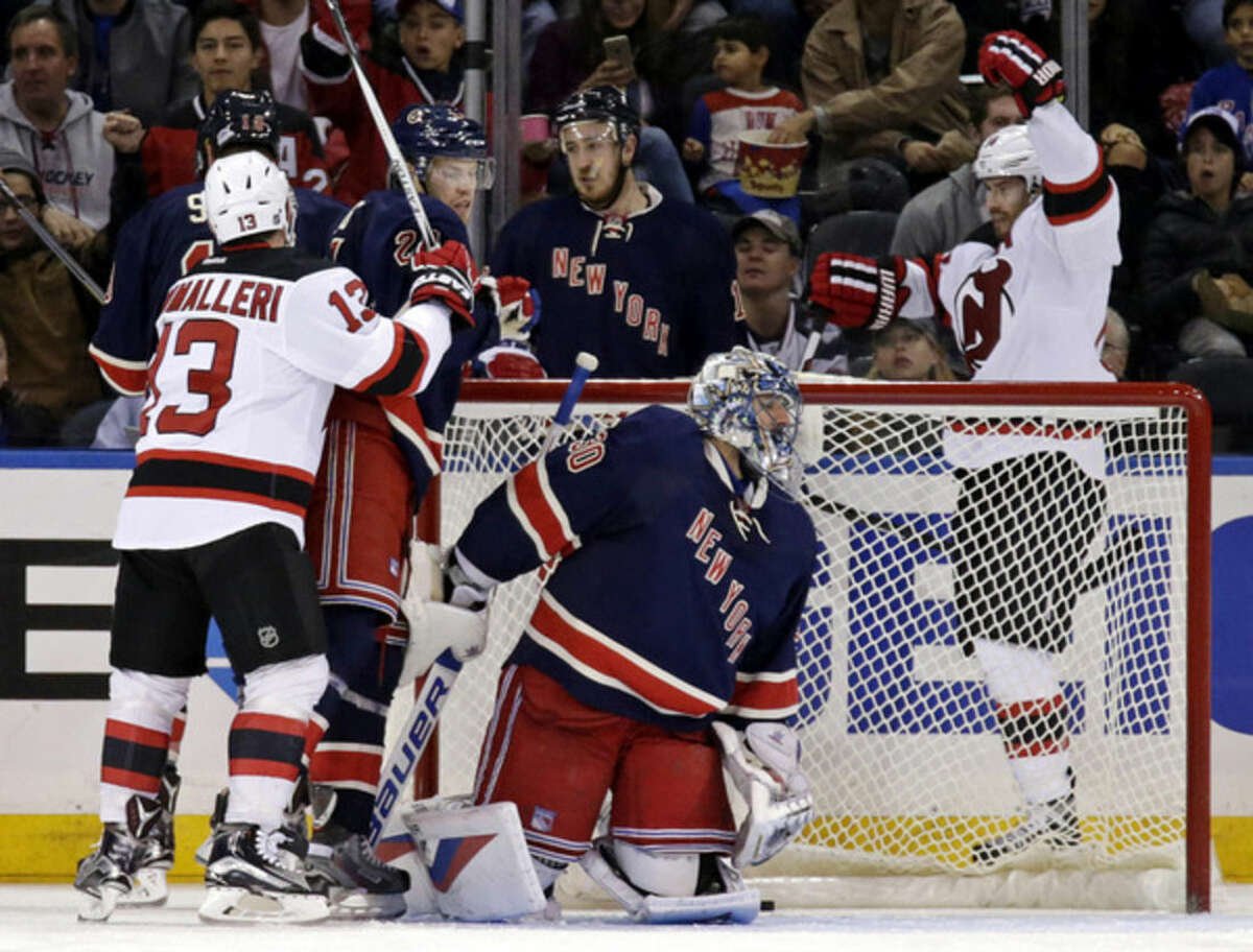 New Jersey Devils center Adam Henrique, right, celebrates after scoring a goal against New York Rangers goalie Henrik Lundqvist, of Sweden, during the second period of an NHL hockey game at Madison Square Garden on Sunday, Oct. 18, 2015, in New York. (AP Photo/Adam Hunger)