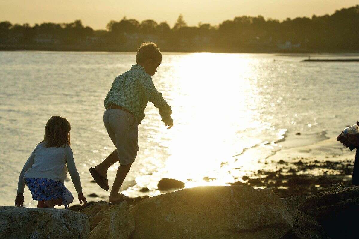 Hour Photo/Alex von Kleydorff. Molly and Colin Woodward walk along the rocks on the seawall after they placed a rose on their Step Mothers name during the Connecticut Remembers September 11th Memorial Ceremony at Sherwood Island state Park, Wednesday evening