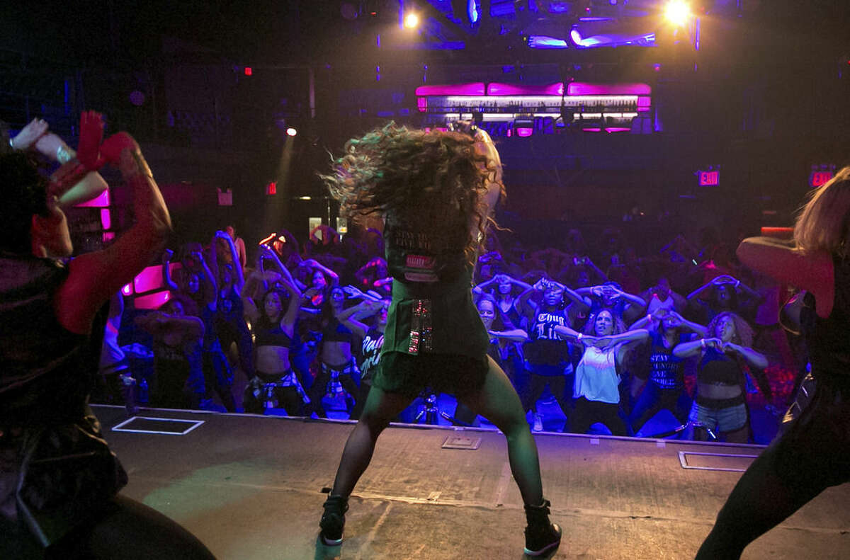 Janet Jones, center, leads a Vixen Workout fitness concert, at the Highline Ballroom, in New York, Saturday, July 26, 2014. Former Miami Heat dancer Janet Jones created the Vixen Workout two years ago after she lost her job as a financial assistant and her high-energy routine has caught on in New York and other cities. (AP Photo/Richard Drew)
