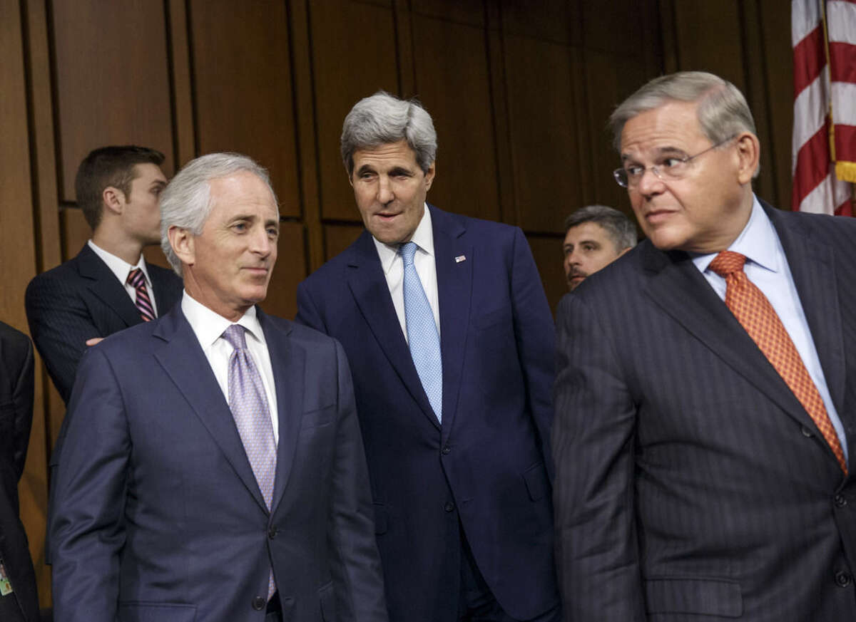 Secretary of State John Kerry, center, is flanked by Senate Foreign Relations Chairman Robert Menendez, D-N.J., right, and Sen. Bob Corker, R-Tenn., the ranking member, left, as he arrives to shore up President Barack Obama's strategy to combat Islamic State extremists in Iraq and Syria, on Capitol Hill in Washington, Wednesday, Sept. 17, 2014.Obama reaffirmed Wednesday that he does not intend to send U.S. troops into combat against the Islamic State group, despite doubts about the ability of Iraqi forces, Kurdish fighters and Syrian rebels to carry out the ground fight on their own. (AP Photo/J. Scott Applewhite)