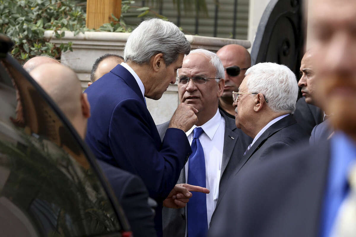U.S. Secretary of State John Kerry, center left speaks with Palestinian President Mahmoud Abbas center right, and close aide to Abbas, Saeb Erekat, center, after their meeting at Abbas' residence in Amman, Jordan, Saturday, Oct. 24, 2015. Kerry said Saturday that Israel and Jordan have agreed on steps aimed at reducing tensions at a holy site in Jerusalem that have fanned Israeli-Palestinian violence. (AP Photo/Raad Adayleh)