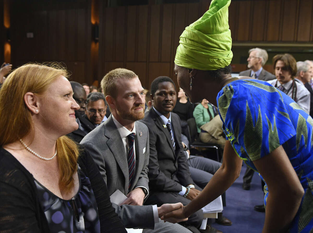 Ebola survivor Dr. Kent Brantly, former Medical Director of Samaritan's Purse Ebola Care Center in Monrovia, Liberia, center, talks with Emira Woods, right, Director of Social Impact at ThoughtWorks, right, before the start of a hearing on Ebola before the Senate Appropriations Subcommittee on Labor, Health and Human Services, and Education on Capitol Hill in Washington, Tuesday, Sept. 16, 2014. Brantly's wife Amber watches at left. Woods thanked Brantly for his work fighting Ebola in Liberia. (AP Photo/Susan Walsh)