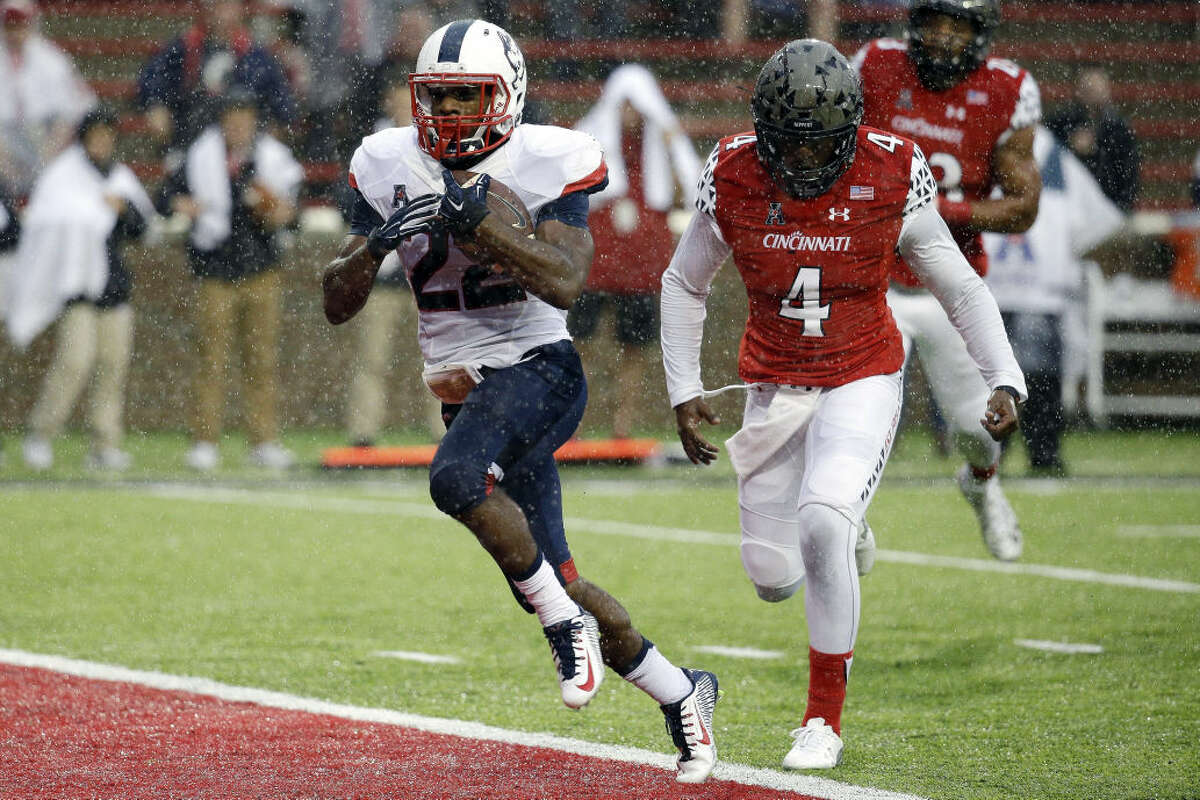 Connecticut running back Arkeel Newsome (22) runs in for a touchdown against Cincinnati safety Zach Edwards (4) in the first half of an NCAA college football game in the rain Saturday, Oct. 24, 2015, in Cincinnati. (AP Photo/John Minchillo)