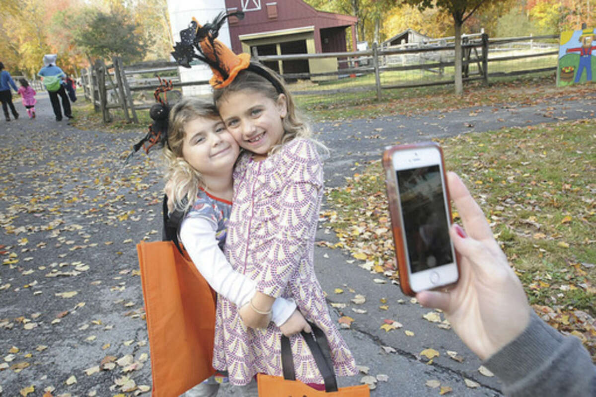 Hour photo Matthew Vinci Sarah Buttacavo, 5, and her sister Alayna, 7, pose for a cellphone photo at the "Ick Fest" held at the Stamford Museum and Nature Center on Sunday.
