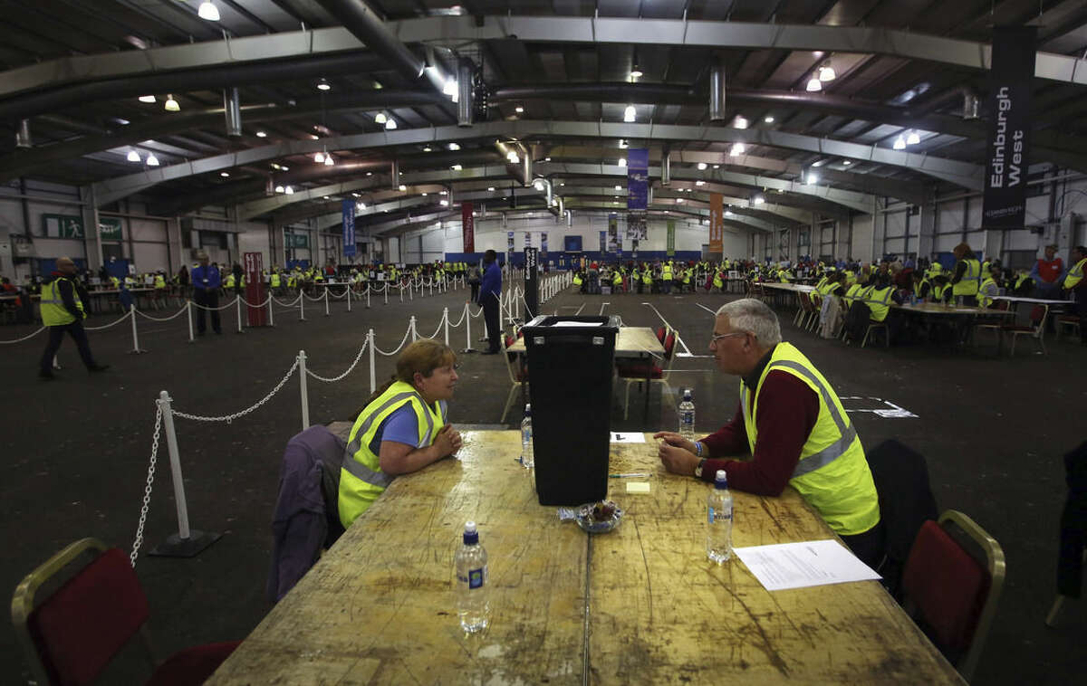Officials wait for ballot boxes to be opened as counting begins in the Scottish Independence Referendum at the Royal Highland Centre in Edinburgh, Scotland, Thursday Sept. 18, 2014. As the polls closed Thursday and vote-counting began, there was a quiet thrill of history in the making on the fog-shrouded streets of Scotland's capital, Edinburgh. Many Scots were staying up all night in homes and bars to watch the results roll in. (AP Photo/David Cheskin)