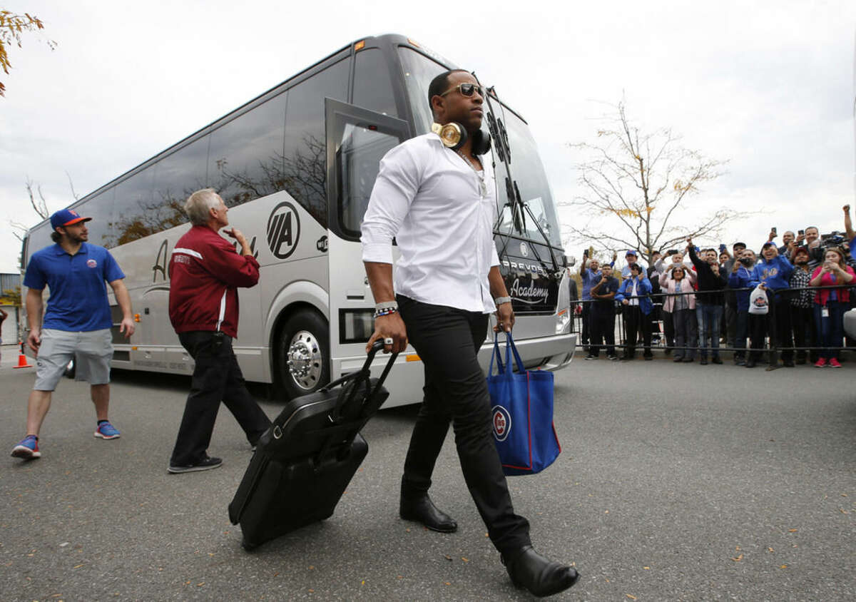 New York Mets' Orlando Cespedes walks with his luggage Thursday, Oct. 22, 2015, in New York. The Mets swept the Chicago Cubs to win the National League Championship. (AP Photo/Kathy Willens)