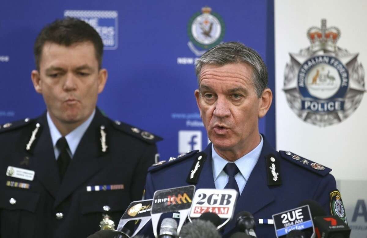 New South Wales Police Commissioner Andrew Scipione, right, and Australian Federal Police Acting Commissioner Andrew Colvin describe how 800 federal and state police officers raided more than two dozen properties as part of the operation in Sydney, Thursday, Sept. 18, 2014. Australian police detained 15 people earlier on Thursday in a major counterterrorism operation, saying intelligence indicated a random, violent attack was being planned on Australian soil. (AP Photo/Rick Rycroft)