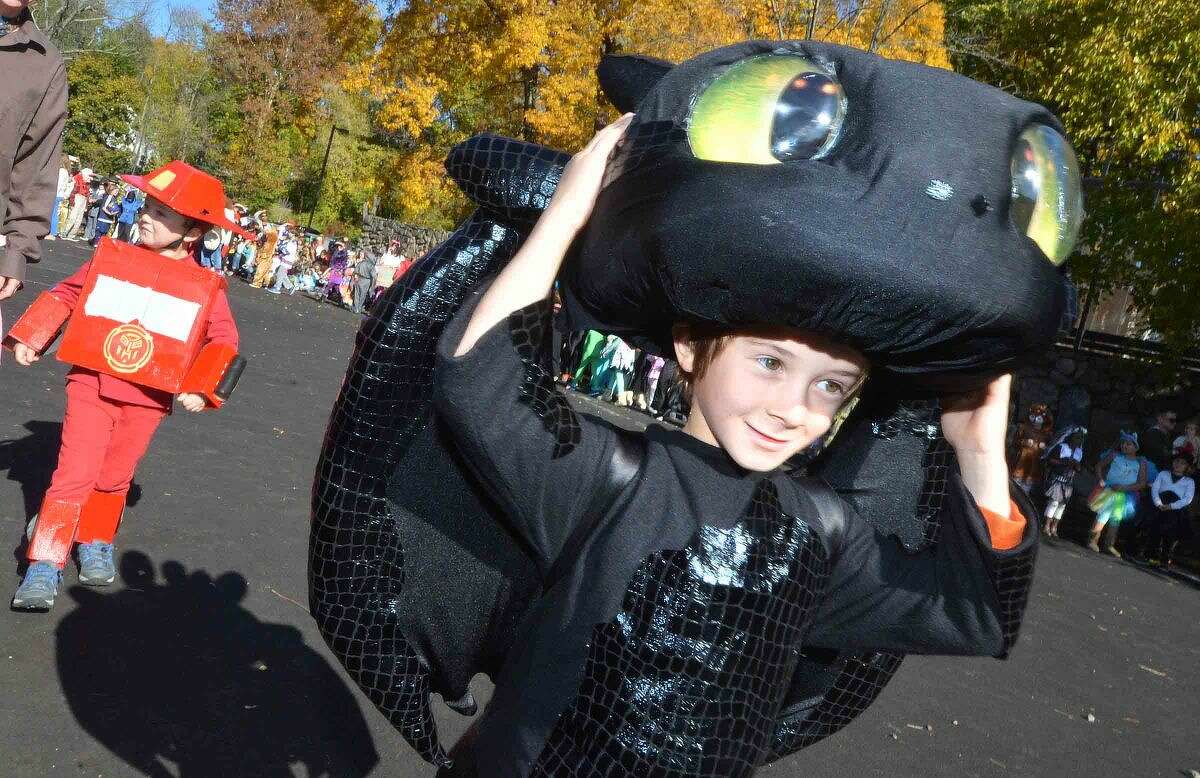 Hour Photo/Alex von Kleydorff Kindergartener Jason Kurtzman holds on at 'Toothless' from How to Train your Dragon during the Rowayton Elementary School's Halloween parade