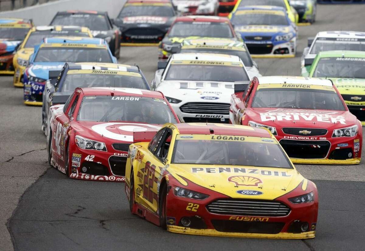 Joey Logano (22) takes the lead on the final restart during the NASCAR Sprint Cup series auto race at New Hampshire Motor Speedway on Sunday, Sept. 21, 2014, in Loudon, N.H. Logano went on to win the race. (AP Photo/Jim Cole)