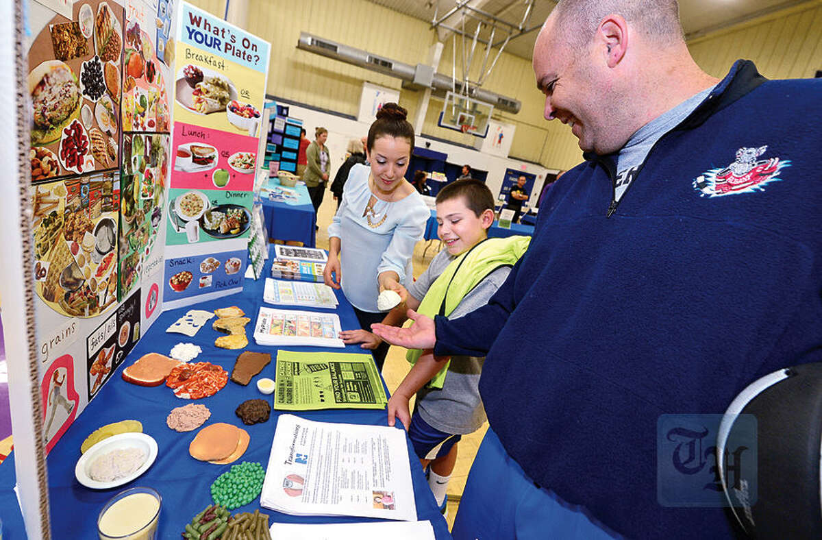 Nico Matik and his dad David get nutrition advice from Dietetic Intern Kelly Gruber during The Hour Publishing Co. and Western Connecticut Health Network annual Health & Wellness Fair at Wilton Family Y Saturday.
