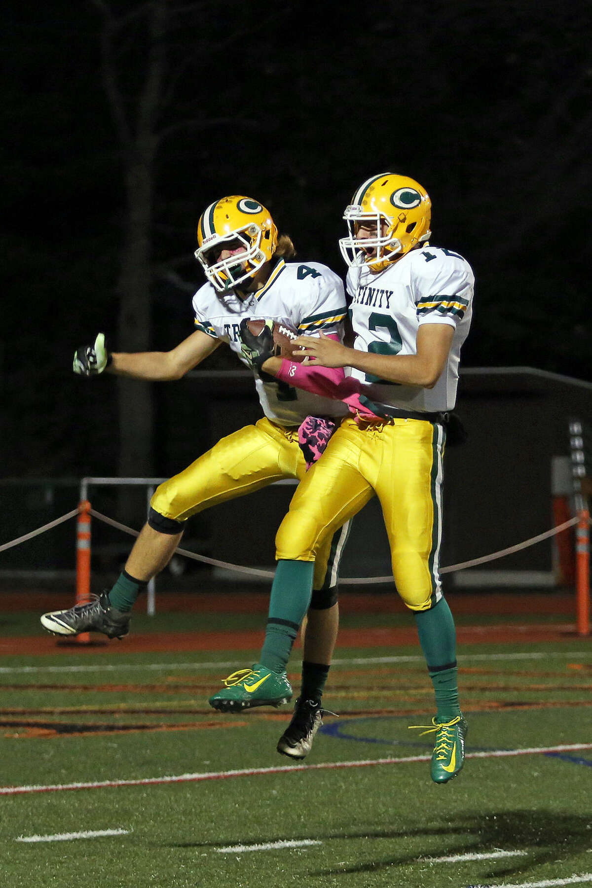 Trinity Catholic's #4, Johnny Somers, is congratulated by #12, Anthony Lombardi, after scoring a touchdown during a game against Stamford High School at Boyle Stadium Friday evening. Hour Photo / Danielle Calloway