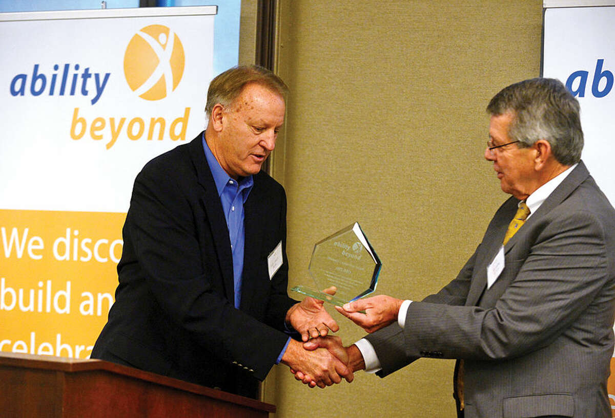 Hour photo / Erik Trautmann Skip Annett of Belimo accepts the Business Leadership Award from Ability Beyond president Tom Fanning as Ability Beyond honors businesses and individuals at 3rd Annual Corporate Recognition Breakfast at Diageo headquarters on Main Ave in Norwalk Friday.