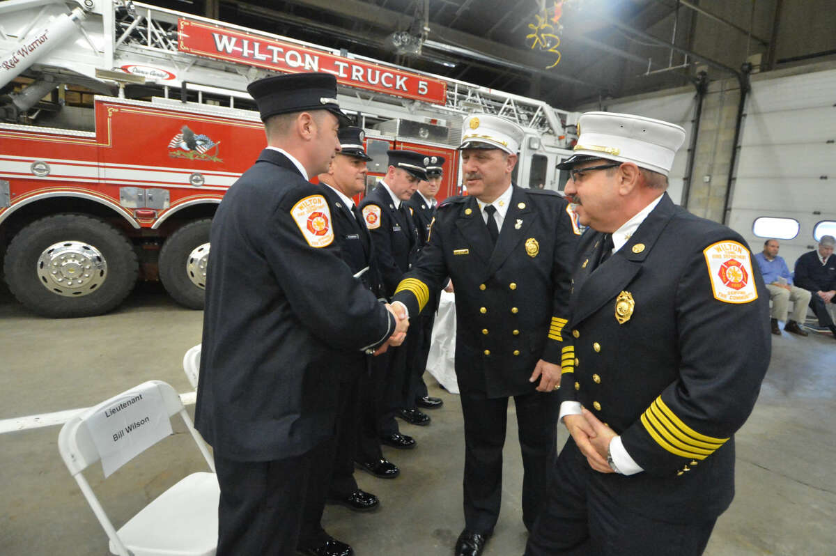 Wilton Fire Chief Ronald Kanterman and Deputy Chief Mark Amatrudo pass out new shields for helmets during a ceremony at Wilton Fire Headquarters that promoted Bill Sampson and Bill Wilson to lieutenant and Firefighters James Blanchfield and Brian Elliott to captain.