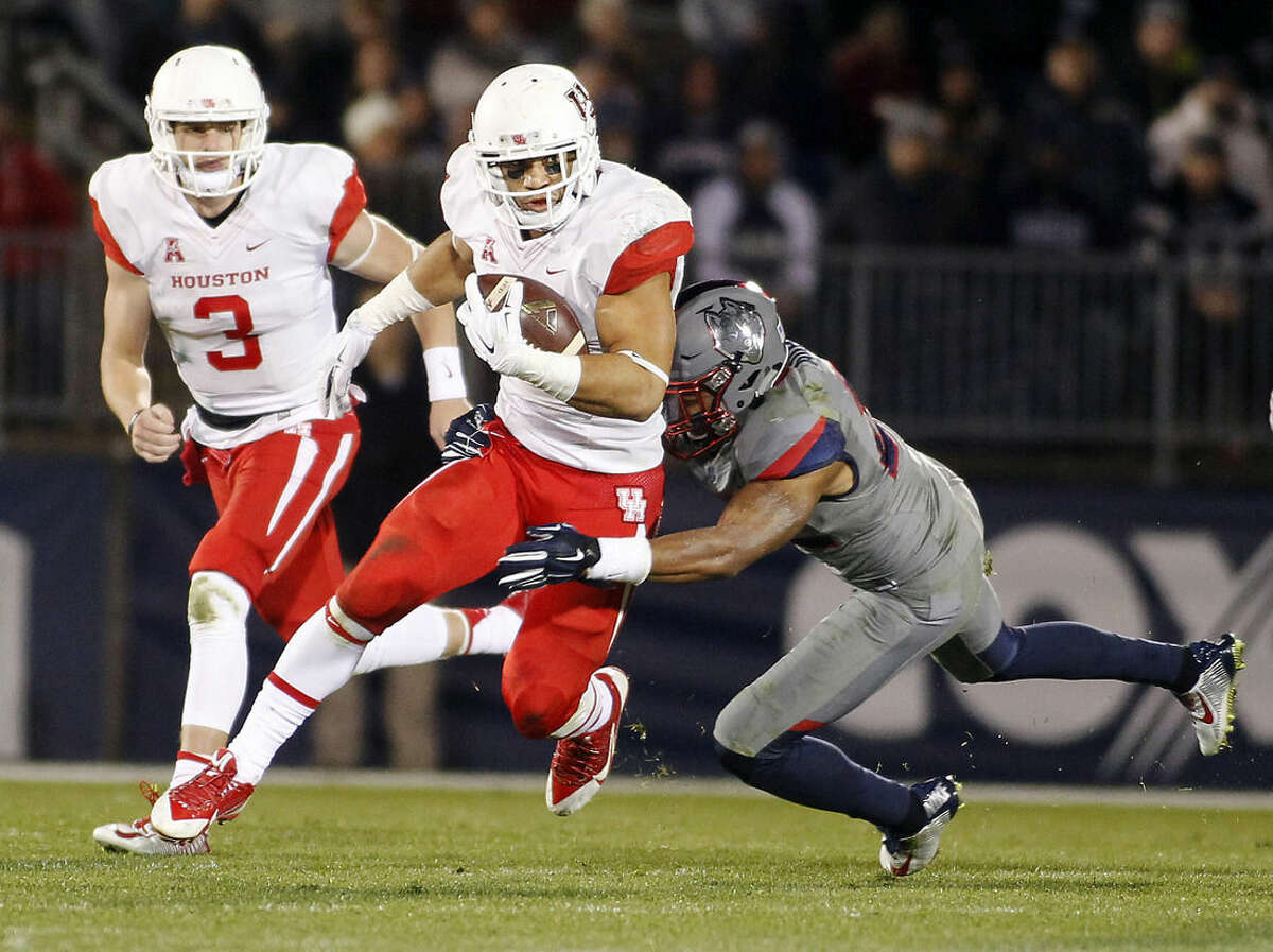 Connecticut safety Andrew Adams, right, tackles Houston running back Kenneth Farrow, center, during the third quarter of an NCAA college football game Saturday, Nov. 21, 2015, in East Hartford, Conn. (AP Photo/Stew Milne)