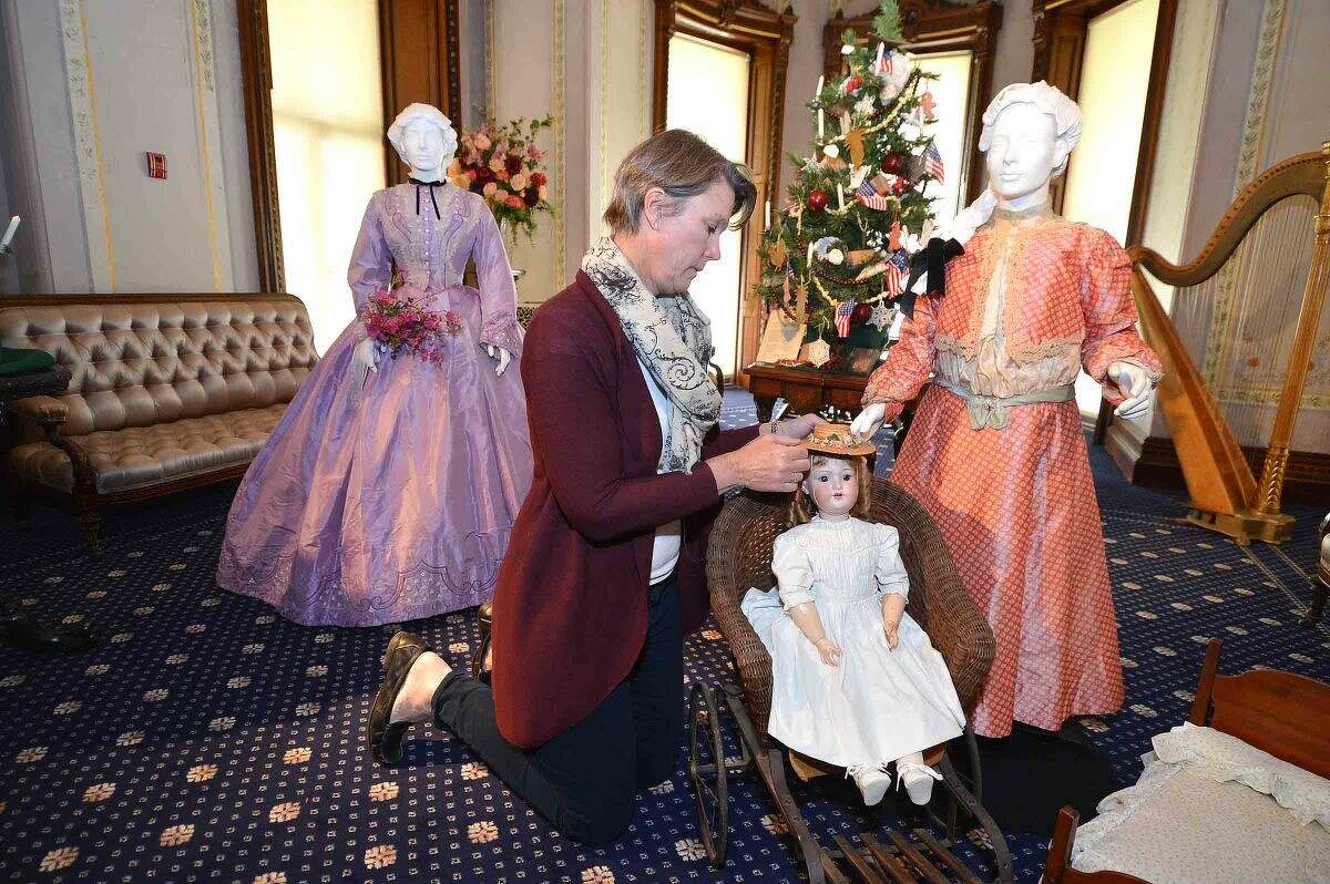 Hour Photo/Alex von Kleydorff Kathie Bennewitz works on setting a doll from the late 19th century in a toy stroller in one of the Vignette's for the new exhibit, Holiday Grandeur: The Mansion's toys and trains story at Lockwood Mathews Mansion Museum