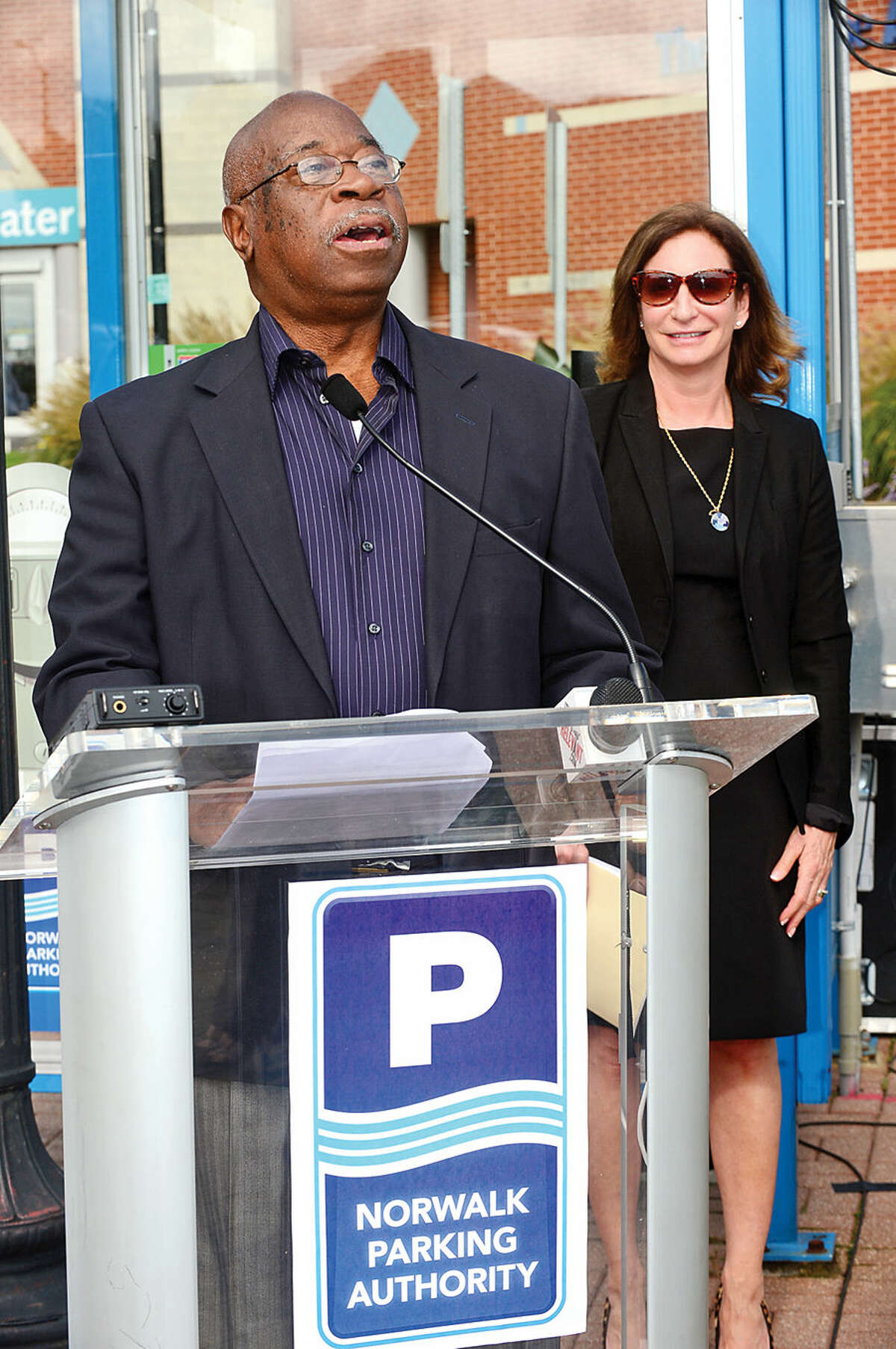 Hour photo / Erik Trautmann Julius Hayward, Chairman of the Norwalk Parking Authority speaks during a press conference at the North Water St lot Tuesday as the Authority announces a new digital initiative that allows access to parking availability information with the smart phone application, Parker. The system works via wireless sensors that are embedded in parking space to detect whether or not the space is occupied. Data from each sensor is relayed via wireless to the cloud and pushed into an easy-to-use app showing real-time parking availability. CASE parking, a parking data solutions provider, will collect occupancy data from the lots and garages. Streetline, the leading global provider of sensor-based smart parking technology, has outfitted the on-street parking spaces with sensors. The data from both systems will be streamed directly into Streetline's mobile app, Parker.